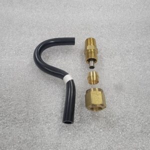 Disassembled brass compression fitting and a bent black tube on a gray surface.