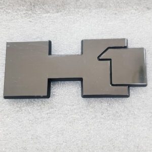 A flat, metallic object with a unique geometric shape and a notch.