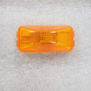 Orange rectangular reflector or light lens on a textured surface.